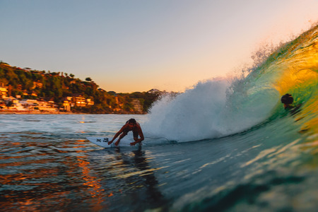 September 8, 2018. Bali, Indonesia. Surfer ride on a wave at a warm sunset. Professional surfing in the ocean, Bingin beachのeditorial素材