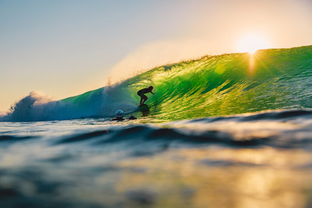 September 8, 2018. Bali, Indonesia. Surfer ride on barrel wave at sunset. Professional surfing in the ocean, Bingin beachのeditorial素材