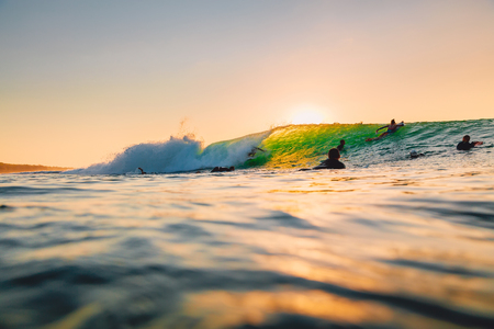 September 8, 2018. Bali, Indonesia. Surfer ride on barrel wave at sunset. Professional surfing in...