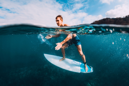Surfer man relaxing with surfboard in oceanの写真素材