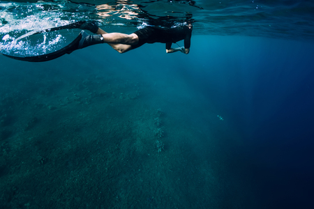 Freediver in wetsuit swimming in the oceanの写真素材