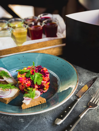 Beetroot salad vinaigrette, sandwiches with fish, alcoholic drinks and black paper card of menuの写真素材