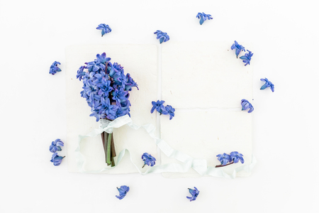 Floral bouquet of hyacinth blue flowers, petals, cards and tapes on white background. Flat lay, top view.の写真素材