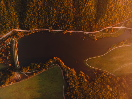 Aerial view of lake, forest and warm sunset or sunrise. Top viewの写真素材