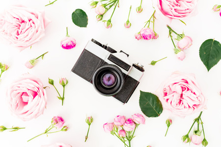 Pink rose flowers with old retro camera on white background. Flat lay, Top view. Valentines day conceptの写真素材