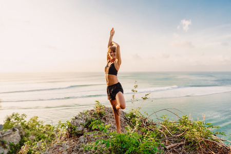 Yoga woman meditation at beach with sunset or sunrise.