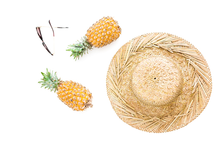 Holidays concept. Pineapple fruits, glasses and straw hat on white background. Flat lay, top view.の写真素材