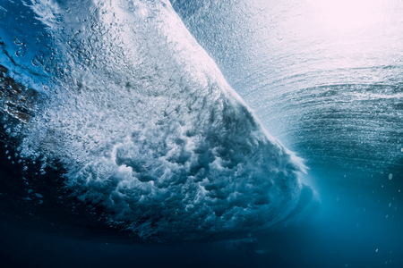 Barrel wave underwater with air bubbles and sun light. Blue crystal ocean in underwaterの写真素材
