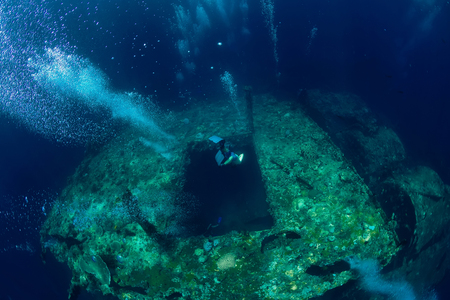 Free diver man dive to shipwreck in ocean, underwaterの写真素材