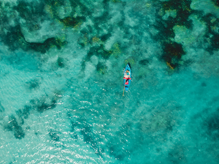 Turquoise crystal ocean water and fisherman on boat, aerial shot. Top viewの写真素材