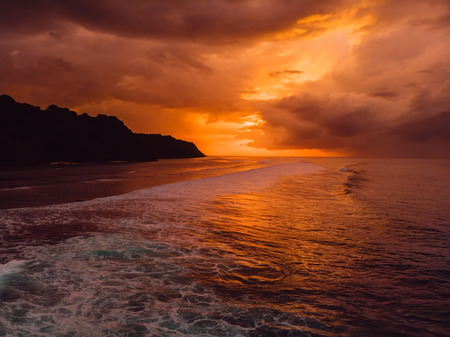 Aerial view of ocean with waves and warm sunset or sunrise.の写真素材