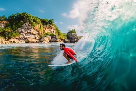April 18, 2019. Bali, Indonesia. Surfer ride on barrel wave. Professional surfing at big waves in...