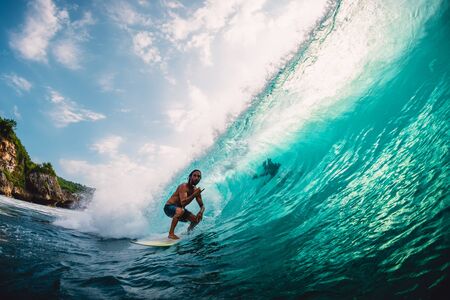 April 18, 2019. Bali, Indonesia. Surfer ride on barrel wave. Professional surfing at big waves in...