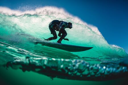 April 18, 2019. Bali, Indonesia. Surfer ride on barrel wave. Professional surfing at big waves in Padang Padangのeditorial素材