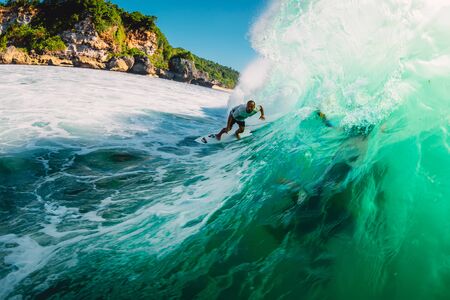 April 18, 2019. Bali, Indonesia. Surfer ride on barrel wave. Professional surfing at big waves in...