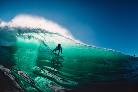 April 18, 2019. Bali, Indonesia. Surfer ride on barrel wave. Professional surfing at big waves in Padang Padangのeditorial素材