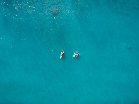 Aerial view of surfers in tropical ocean. Top view