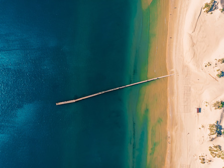 Top view of beach with blue sea and pier, aerial viewの写真素材