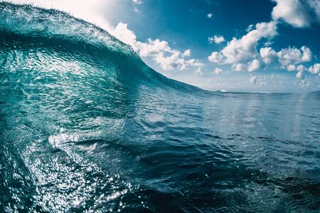 Blue barrel wave in ocean. Breaking wave and sun lightの写真素材