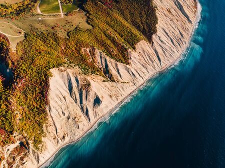Aerial view of rocky shore with cliff and blue seaの写真素材