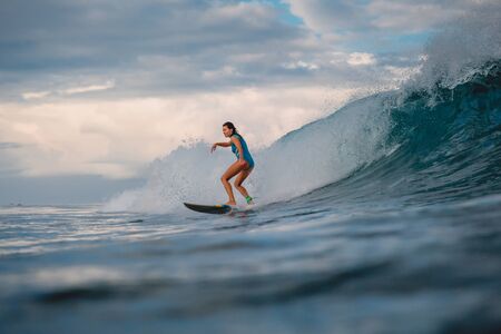 Surf girl on surfboard. Woman in ocean during surfing. Surfer and waveの写真素材