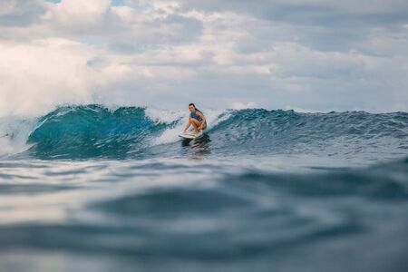 Surf girl on surfboard. Woman in ocean during surfing. Surfer and waveの写真素材