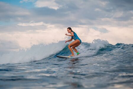 Surf girl on surfboard. Woman in ocean during surfing. Surfer and wave