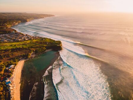 Aerial view with waves at warm sunset. Ideal ocean waves for surfing in Baliの写真素材