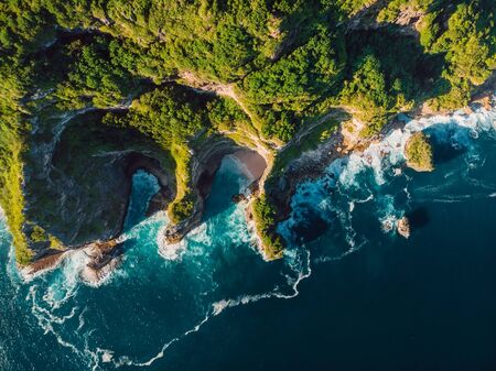 Amazing cliff, rocks and blue ocean with waves in Bali. Aerial viewの写真素材