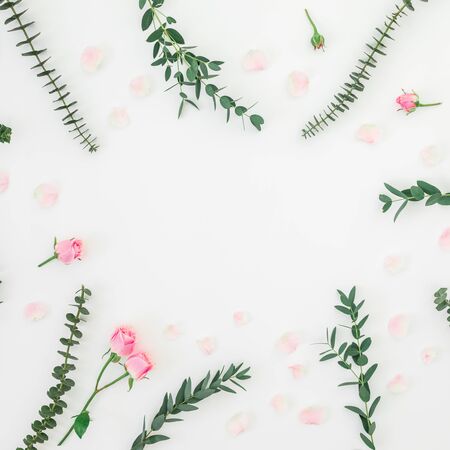 Floral frame made of roses flowers and eucalyptus branches on white. Flat lay, top viewの写真素材