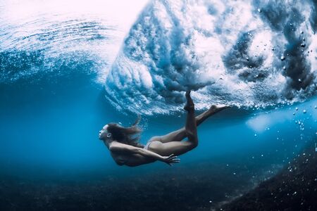 Woman swim underwater with ocean wave.の写真素材