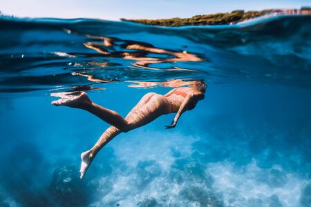 February 20, 2019. Bali, Indonesia Woman in bikini swim and dive underwater in blue oceanのeditorial素材