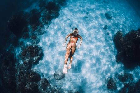 February 20, 2019. Bali, Indonesia Woman in bikini swim and dive underwater in blue ocean