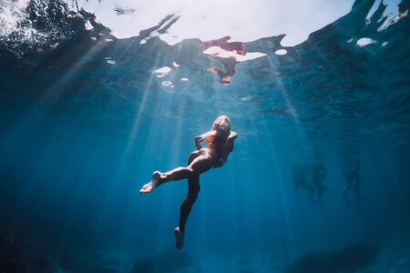 February 20, 2019. Bali, Indonesia Woman in bikini swim and dive underwater in blue oceanのeditorial素材