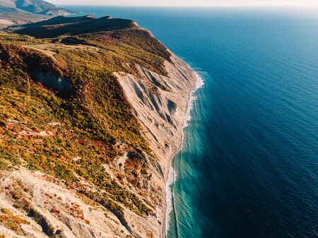Aerial view of rocky cliff, coastline and sea with waves in Anapa