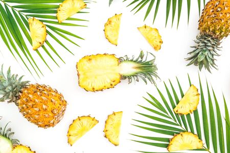 Pattern with sliced pineapple and palm leaves on white background. Flat lay, top view.の写真素材