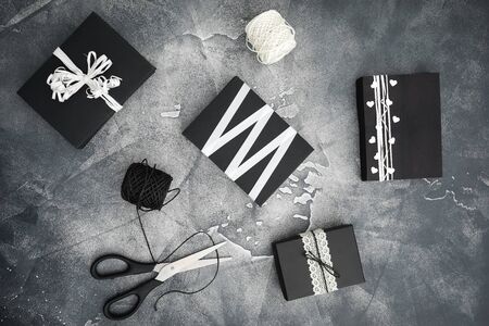 Christmas gifts with scissors and twine on dark. Preparation for the holiday. Flat lay. Top viewの写真素材