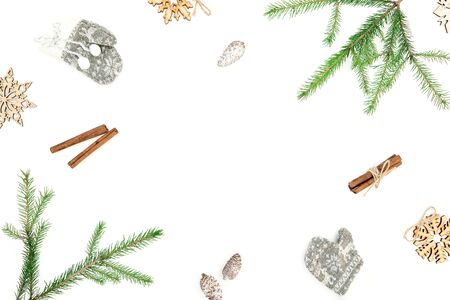 Christmas frame of fir branches and cinnamon with decor on white background. Flat lay. top view. New...