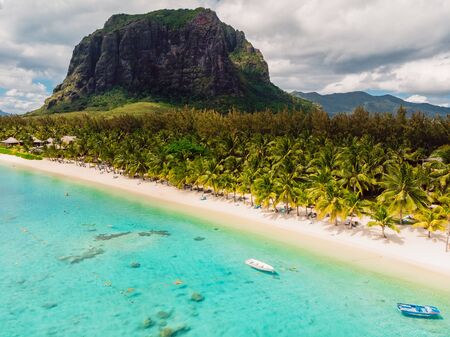Luxury beach with mountain in Mauritius. Sandy beach with palms and blue ocean. Aerial viewの写真素材