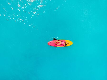Attractive woman relax on stand up paddle board in blue ocean.の写真素材
