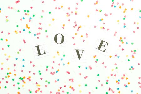 Valentines day composition with Love word and colorful confetti on white background. Flat lay, top view.の写真素材