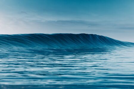 Blue crystal wave in ocean. Breaking wave and sun lightの写真素材
