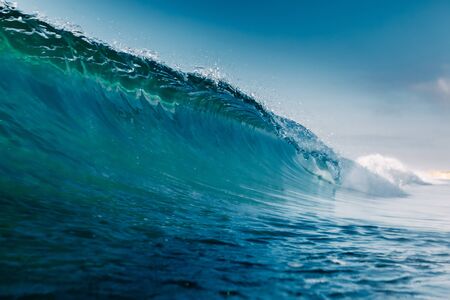 Blue crystal wave in ocean. Breaking wave and sun light