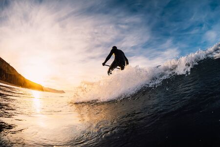 December 28, 2019. Anapa, Russia. Stand Up Paddle surfing on waves. SUP board and surfer in wetsuit...