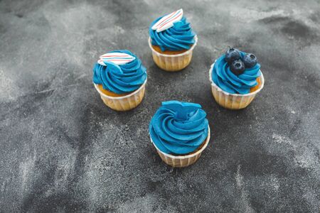Blueberry muffins with blue cream on dark background. Flat lay, top viewの写真素材