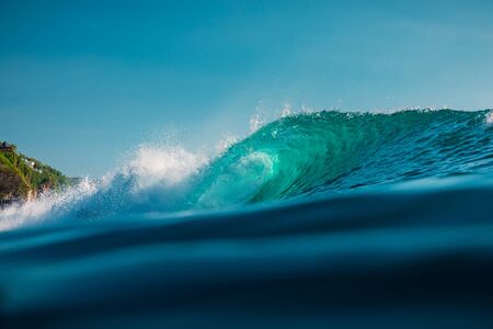 Barrel wave in ocean. Blue wave with sun lightの写真素材