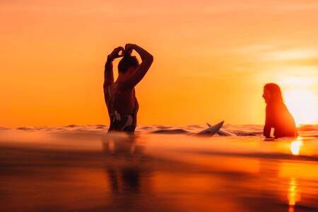 25 april 2019. Bali, Indonesia. Attractive surfer woman on a surfboard in ocean. Surfgirl at sunset