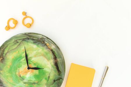 Ð¡lock resin art with diary and earrings on white background. Flat lay, top viewの写真素材