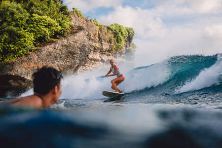 March 15, 2020. Bali, Indonesia. Surfer girl on surfboard. Woman in ocean during surfing.のeditorial素材