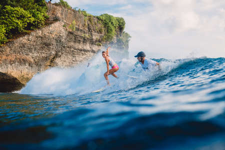 March 15, 2020. Bali, Indonesia. Surfer girl on surfboard. Woman in ocean during surfing.のeditorial素材